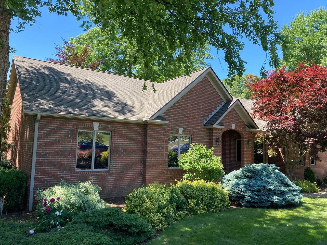 Completed residential metal roof installation on a white home, showcasing professional workmanship, timely service, and thorough cleanup after the project.