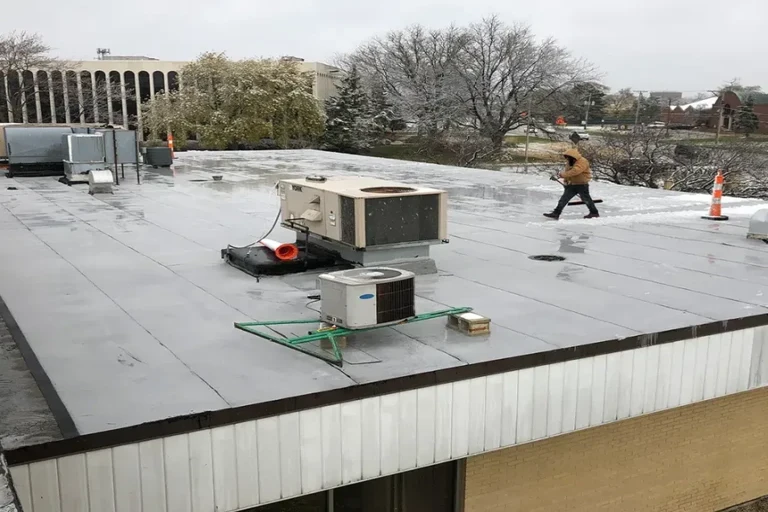 Hometown Roofer inspecting a flat commercial roof after a long winter